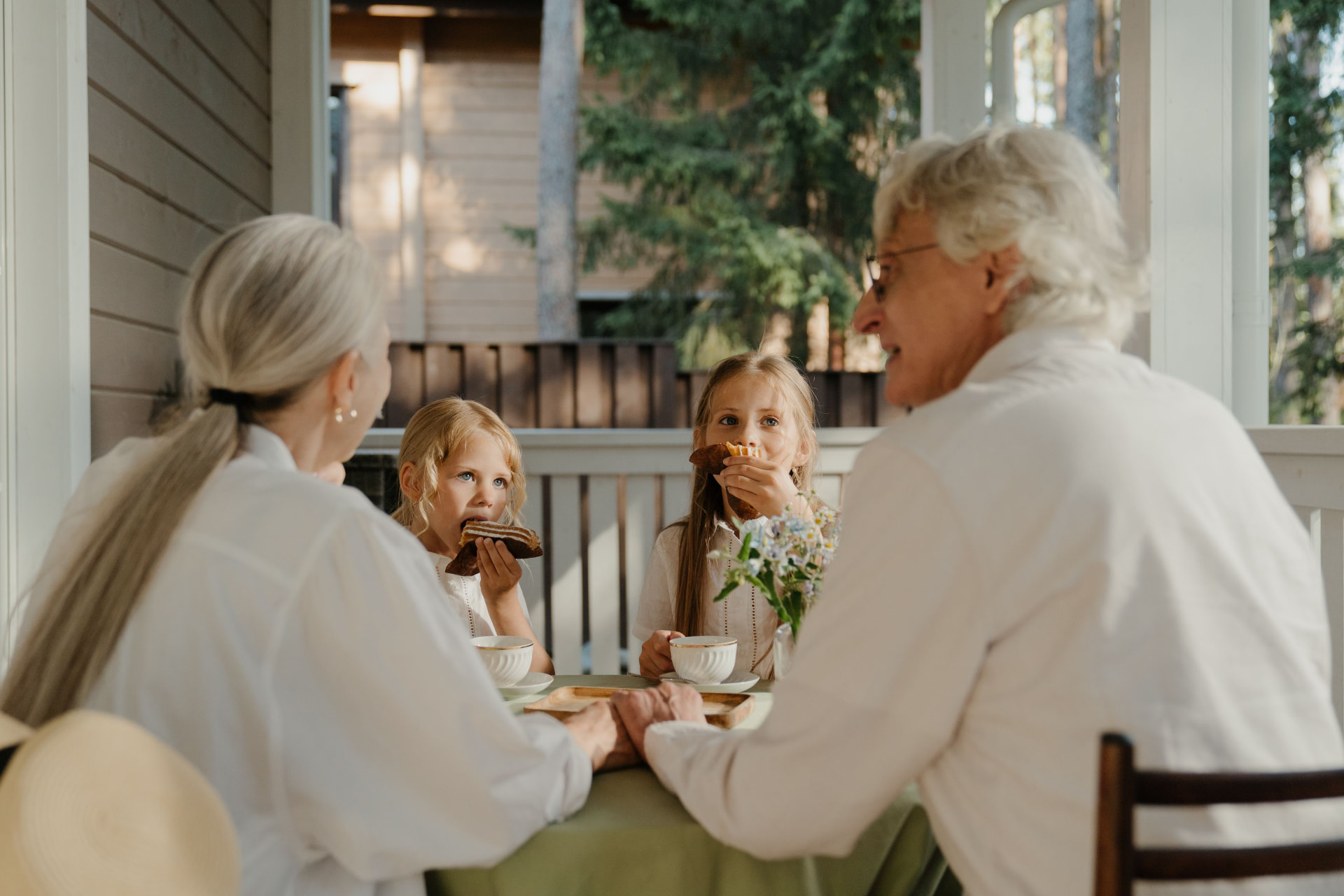 Older adults sharing tea and conversation on a sunlit porch